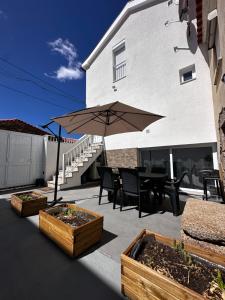 a patio with a table and an umbrella at Casa do Castelo in Valhelhas