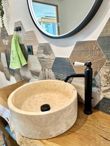 La salle de bains est pourvue d'un lavabo en bois et d'un miroir. dans l'établissement La Grange - Gîte de Prestige La Rochelle, à Saint-Médard-dʼAunis 19 autres photos