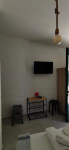 uma sala de estar com televisão numa parede branca em Papatsas Center Houses em Nydri