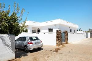 um carro estacionado em frente a uma casa branca em Casa Rosa em Roche