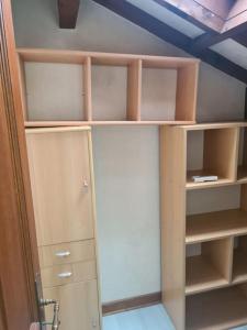 an empty closet with wooden shelves and a ceiling at Maison accessible à tous avec piscine! in La Tronche