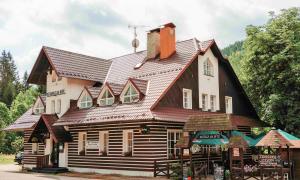 uma grande casa de madeira com um telhado de gambrel em Hotýlek na Mýtě em Harrachov