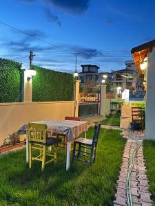 a table and chairs in a yard with a patio at NEŞELİ APART BAHÇE CAFE in Seferihisar