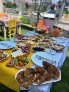 uma mesa longa com pratos de comida em NEŞELİ APART BAHÇE CAFE em Seferihisar