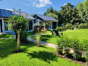 a house with a bench in a yard at Park De Driesprong in Nieuwveen