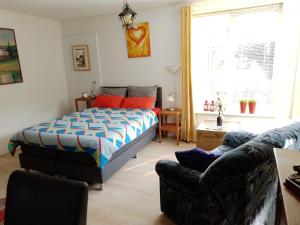 een slaapkamer met een bed en een bank bij Drenthse-Groninger landschap in Haren