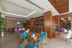 a restaurant with tables and chairs and purple chairs at Lamec Hotel Business in Gebze