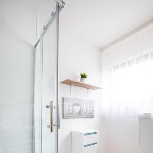 La salle de bains est pourvue d'une douche et d'une porte en verre. dans l'établissement Ferienwohnung Kirschblüte, 