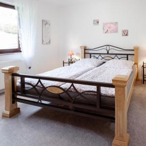 1 dormitorio con 1 cama grande con marco de madera en Ferienwohnung Kirschblüte 