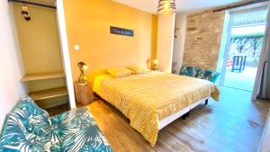 - une chambre avec un lit et un mur jaune dans l'établissement La Grange - Gîte de Prestige La Rochelle, à Saint-Médard-dʼAunis