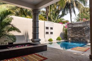 un patio con piscina y una casa en Neeleshwar Hermitage, en Nīleshwar