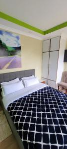 1 dormitorio con 1 cama grande y una pintura en la pared en The Cot, en Kitengela 