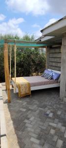 a bed under a canopy on a patio at The Cot in Kitengela 