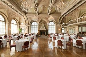 un comedor con mesas y sillas blancas y lámparas de araña en QC Terme Grand Hotel Bagni Nuovi, en Bormio 37 fotos más