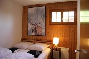 a bedroom with two beds and a picture of a deer at Chalet Antoine 5p in Moleson
