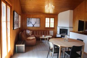 a living room with a couch and a table at Chalet Antoine 5p in Moleson