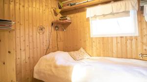 Un dormitorio con una cama blanca y una ventana. en Northen Lights Cabin, Riverside, Mountain view, en Rjúpnavellir
