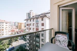 einen Balkon mit einem Tisch und Stadtblick in der Unterkunft Lovely Flat w Balcony 10 min to Moda Coast in Istanbul