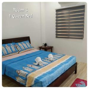 a bedroom with a bed with a blue comforter at 80Square Guest House in Gingoog