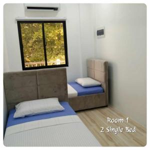 a small bedroom with a bed and a window at 80Square Guest House in Gingoog