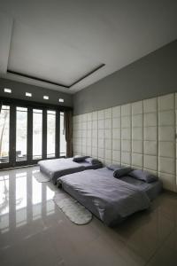 2 Betten in einem Zimmer mit Fenstern in der Unterkunft Tropical Bliss Villa by The Feelas in Bandung
