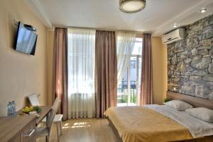 a bedroom with a bed and a stone wall at Golden Gate Inn in Kyiv