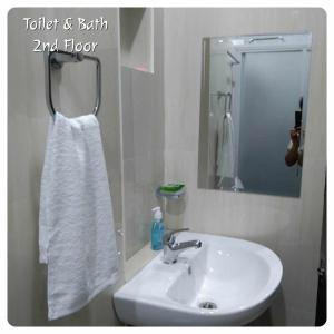 bagno con lavandino, specchio e asciugamano di 80Square Guest House a Gingoog