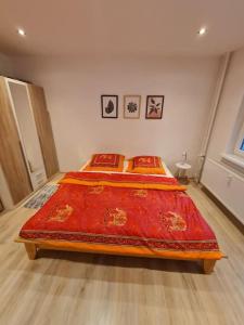 a bedroom with a bed with a red blanket on it at Apartmán Horný Smokovec in Vysoke Tatry - Horny Smokovec