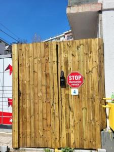 a stop sign on the side of a wooden fence at Gara de Nord-Banat-4-You in Bucharest