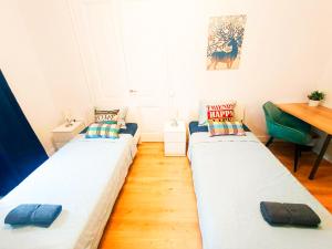 Habitación pequeña con 2 camas y escritorio. en By Born & Gothic Rooms, en Barcelona