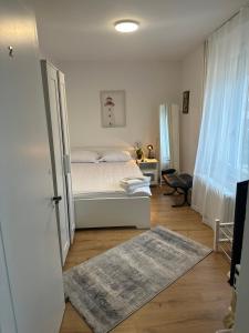 a bedroom with a white bed and a rug at NTN HOUSE in St. Gallen