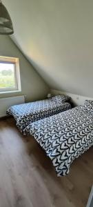 een bed met een zwart-wit dekbed in een kamer bij le Repaire des Loups 