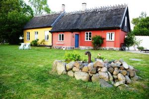 una casa rossa e gialla con un muro di roccia di fronte di Onkel Enkels Pensionat a Tomelilla