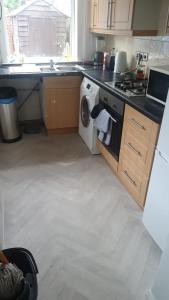 a kitchen with a stove and a washing machine at Room shared in 3bedroom house in Oldham Manchester in Moorside