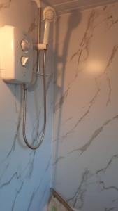 um chuveiro na casa de banho com uma parede de mármore branco em Room shared in 3bedroom house in Oldham Manchester em Moorside