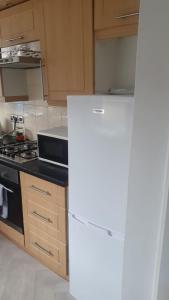 Il comprend une cuisine équipée d'un réfrigérateur blanc et d'une cuisinière. dans l'établissement Room shared in 3bedroom house in Oldham Manchester, à Moorside