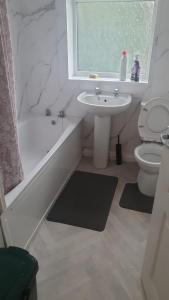 uma casa de banho com um lavatório, uma banheira e um WC. em Room shared in 3bedroom house in Oldham Manchester em Moorside