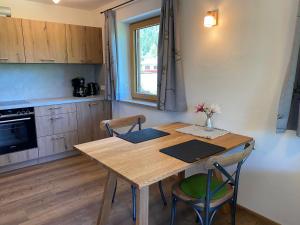 une cuisine avec une table en bois et deux chaises dans l'établissement Ferienwohnungen Artenreitwinkl Hallinger, à Schönau am Königssee