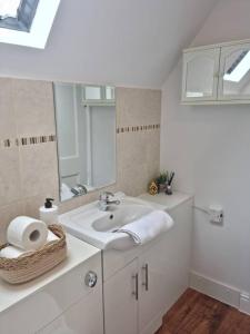 a white bathroom with a sink and a mirror at Hyland Apartment by CityNest in Chelmsford