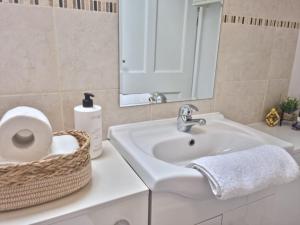 a bathroom with a sink and a mirror and a basket at Hyland Apartment by CityNest in Chelmsford