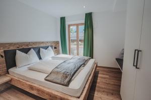 a bedroom with a large bed with green curtains at Seeberhof - Urlaub am Bauernhof in San Giacomo