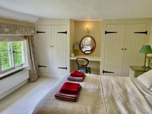 a bedroom with a bed with red pillows on it at Bartley Mill Farmhouse in Wadhurst