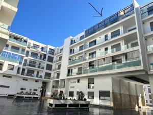 Luxury Apartment in Agadir Bay في أغادير: عمارة سكنية كبيرة بيضاء مع ساحة فناء