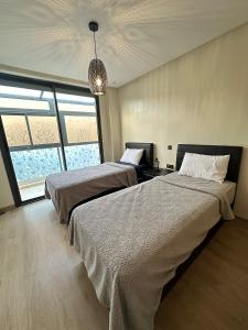 Luxury Apartment in Agadir Bay في أغادير: غرفة نوم بسريرين وثريا