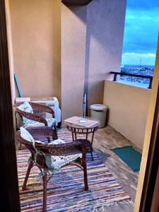 Zimmer mit 2 Stühlen und einem Tisch auf dem Balkon in der Unterkunft Lazuren Bryag Lux suite in Burgas City