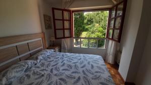 a bedroom with a bed and a large window at APARTAMENTO EN CANDAS CON GARAJE in Candás