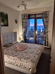 sypialnia z dużym łóżkiem i dużym oknem w obiekcie Lazuren Bryag Lux suite w Burgas