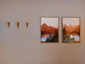 tres cuadros colgando de una pared blanca en MyDeer - Deluxe rooms & shared kitchen en Malmedy