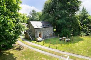 een klein stenen huis midden in een tuin bij Converted Granary on a rural small holding in Cross Inn