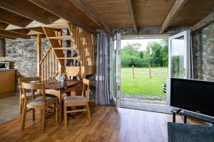 een eetkamer met een tafel en een groot raam bij Converted Granary on a rural small holding in Cross Inn